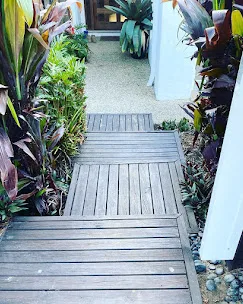 Pruned and tidied garden beds along a walkway in Arundel